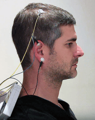man with the neuroptimal sensors on scalp and ear read your brainwaves nothing is added to your brain